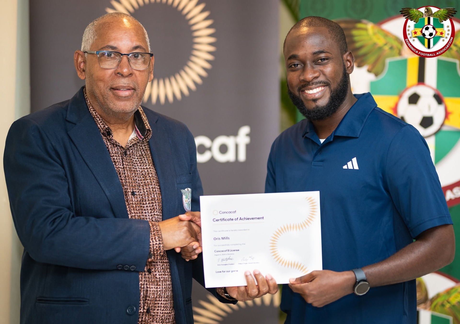 Oris Mills receiving his CONCACAF B License Certificate from President of the DFA Glen Etienne